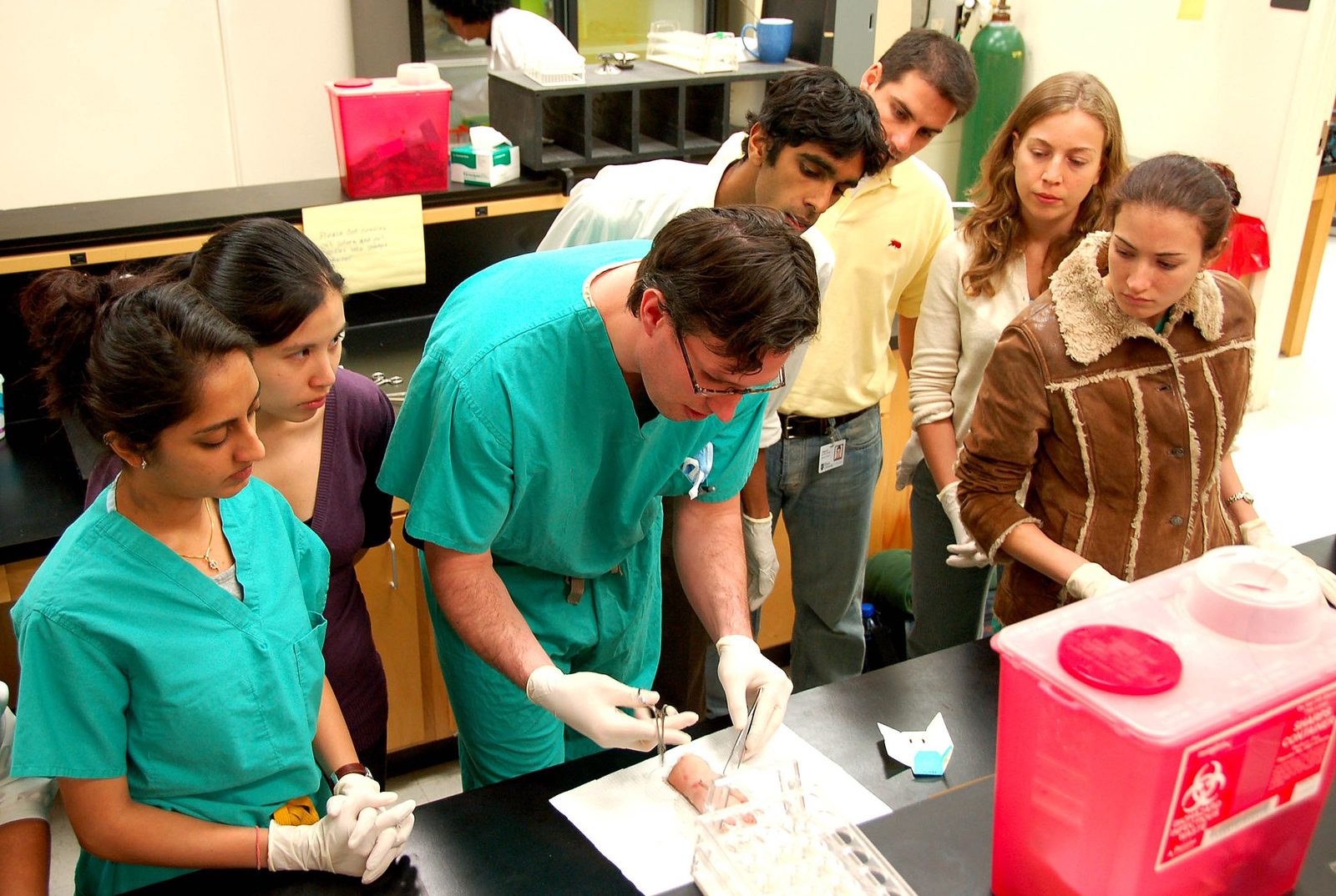 Medical students practising suturing technique during a hands-on training session.